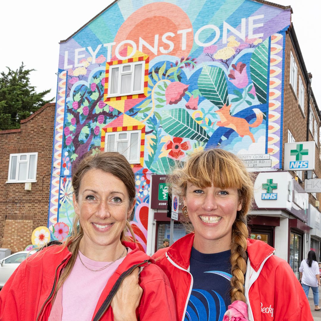 A photograph of the artists Becky Bolton and Louise Chappell in front of the Leytonstone mural on the High Street, Leytonstone.