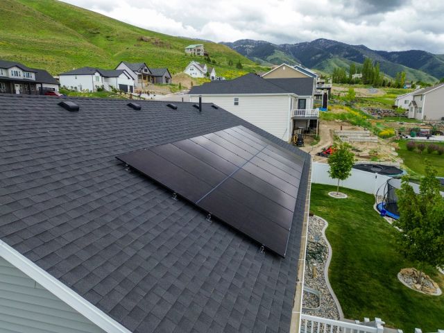 Close view of a rooftop solar array above a backyard