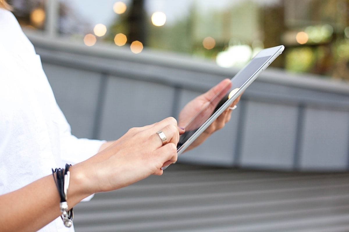 A woman signing a digital waiver on an iPad.