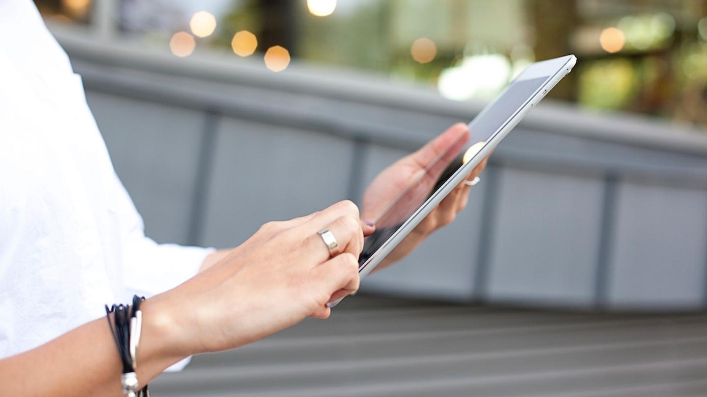 A woman signing a digital waiver on an iPad.