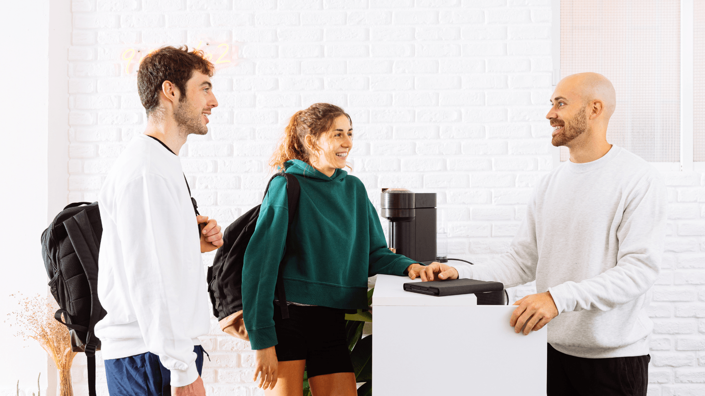 Two guests making a direct booking at a hotel reception counter.