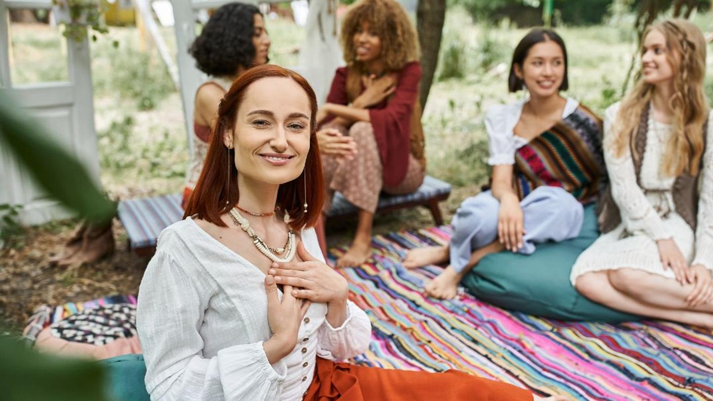 A wellness retreat leader sitting with a group of women.