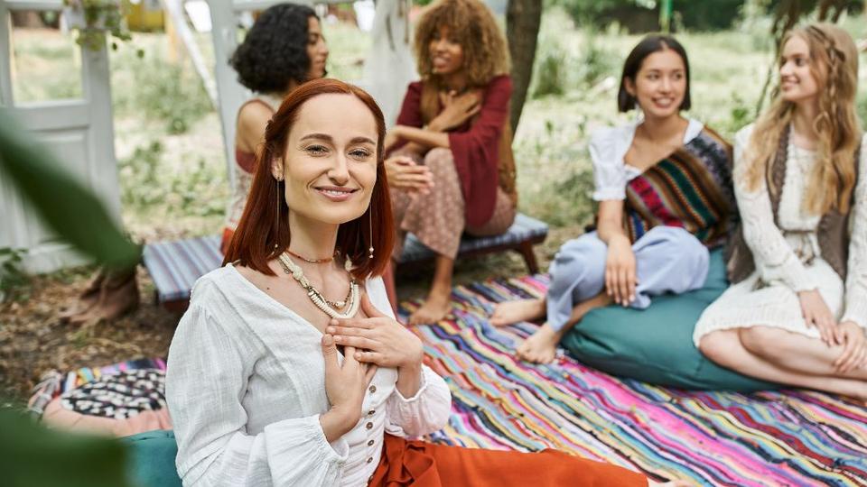 A wellness retreat leader sitting with a group of women.