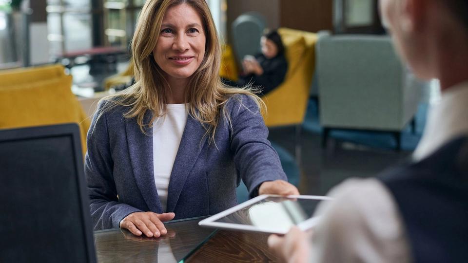A woman using an iPad to check-in to a sustainable hotel.