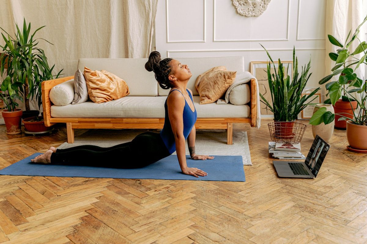 A women taking an online yoga class in her living room.