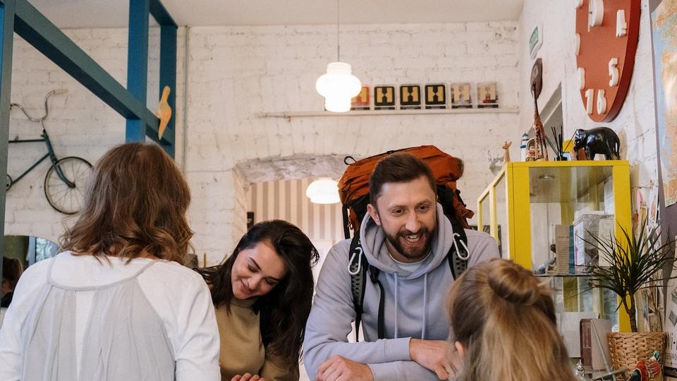 Two guests checking in at the front desk of a hostel.