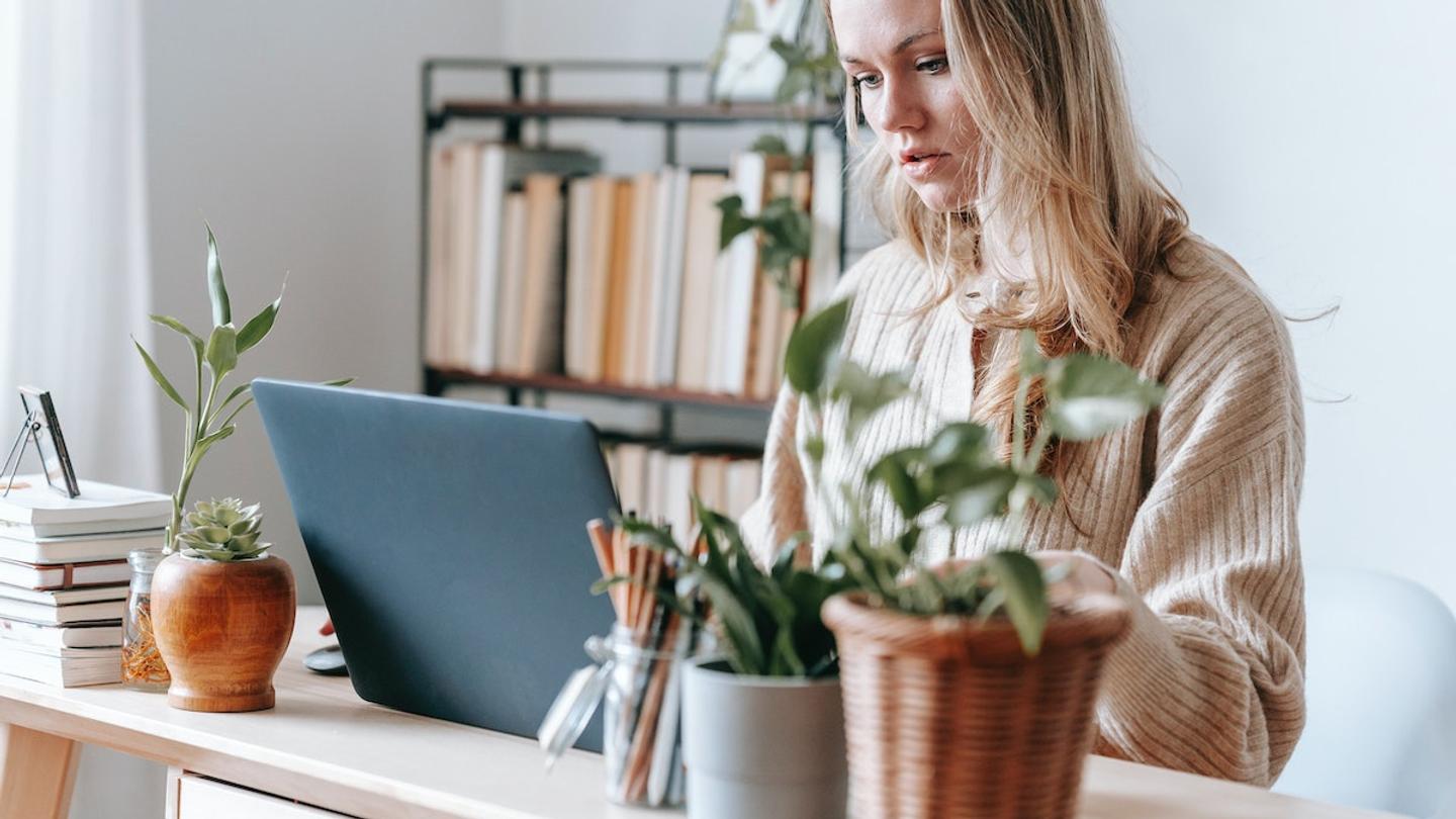 A woman sitting at a desk using a laptop.
