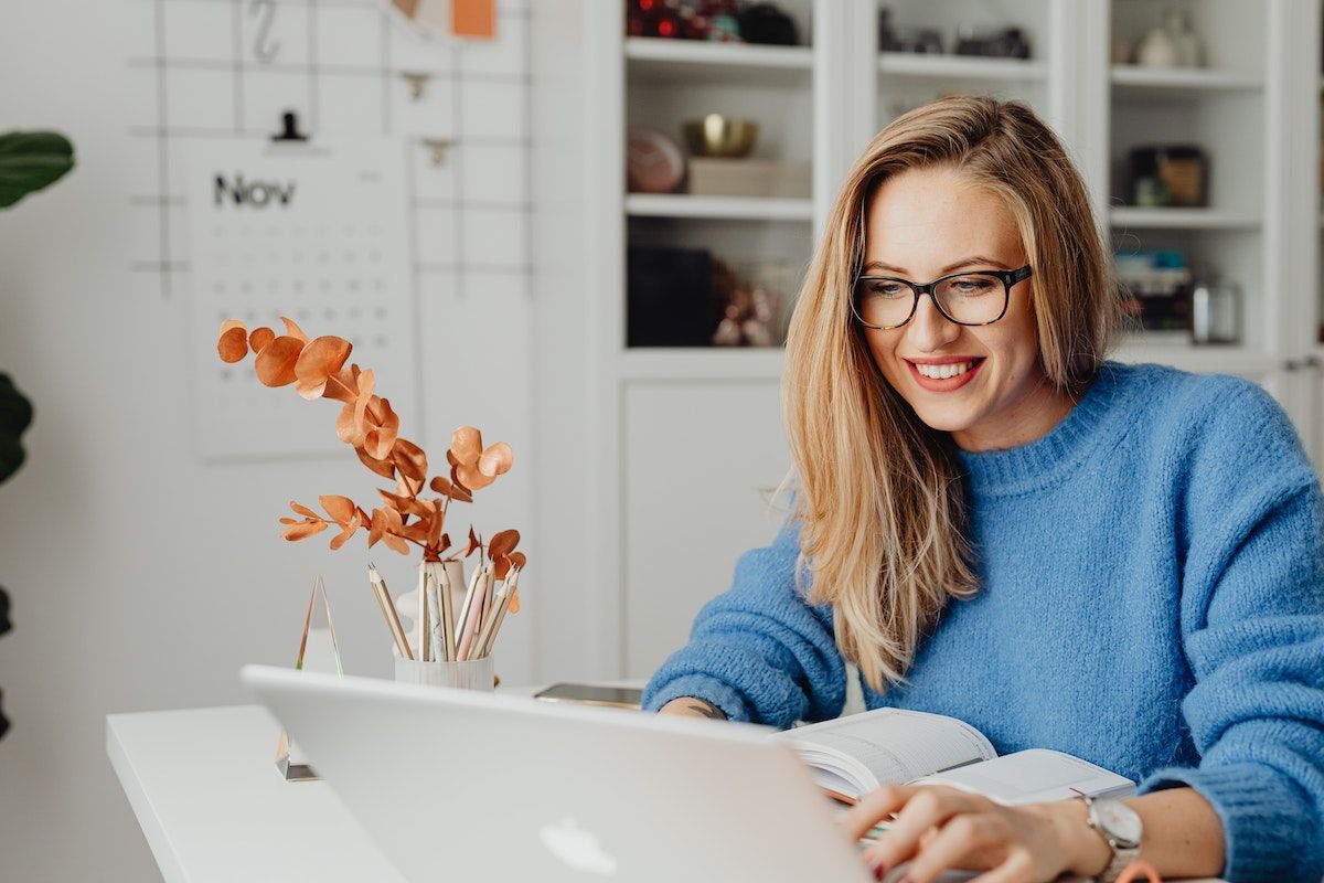 A young woman using Bookinglayer's hotel reservation system on a laptop.
