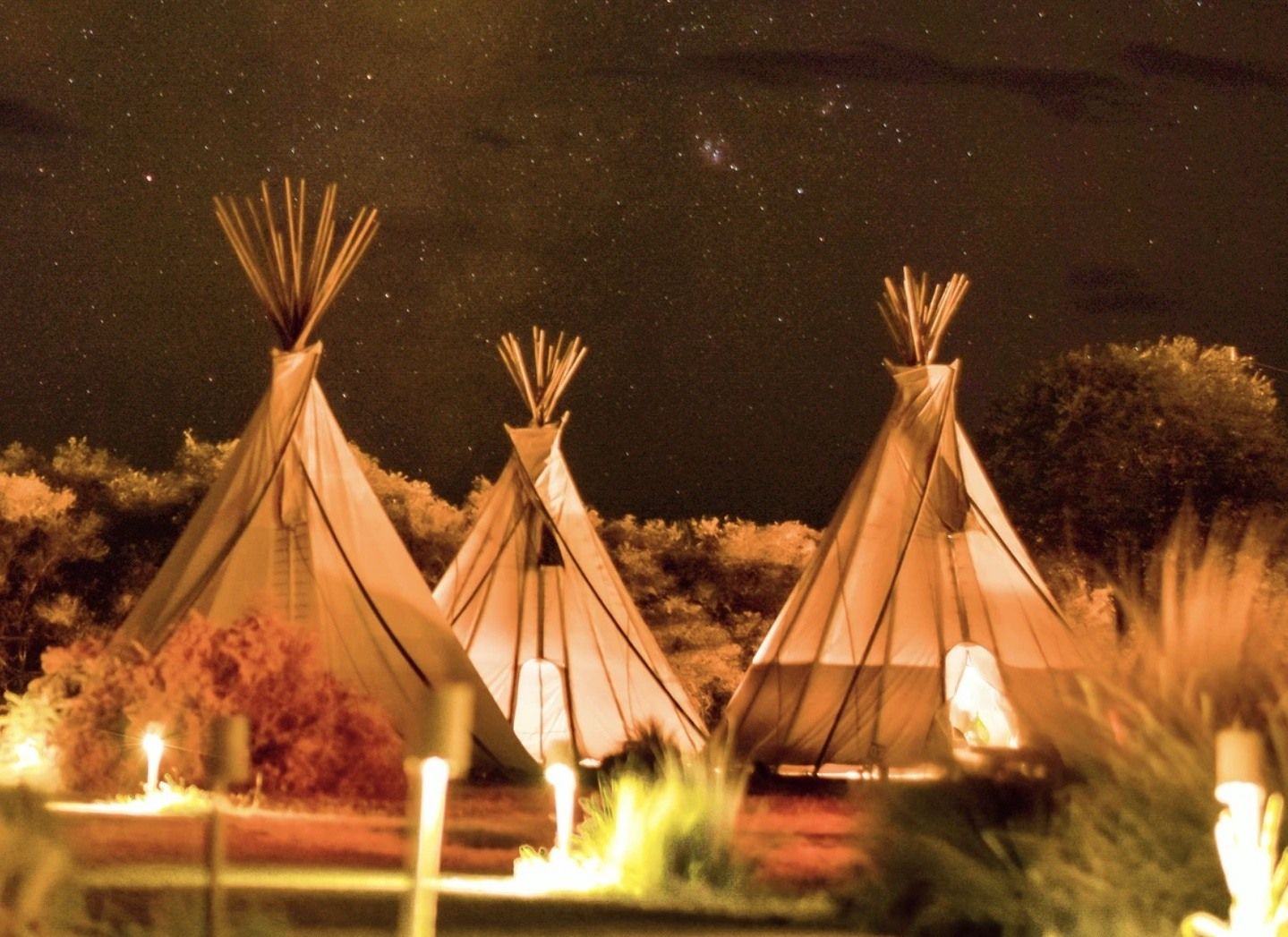 Three glamping tipis at night.
