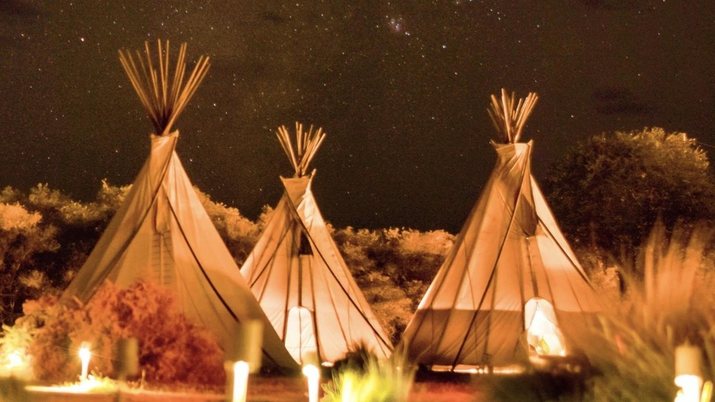 Three glamping tipis at night.