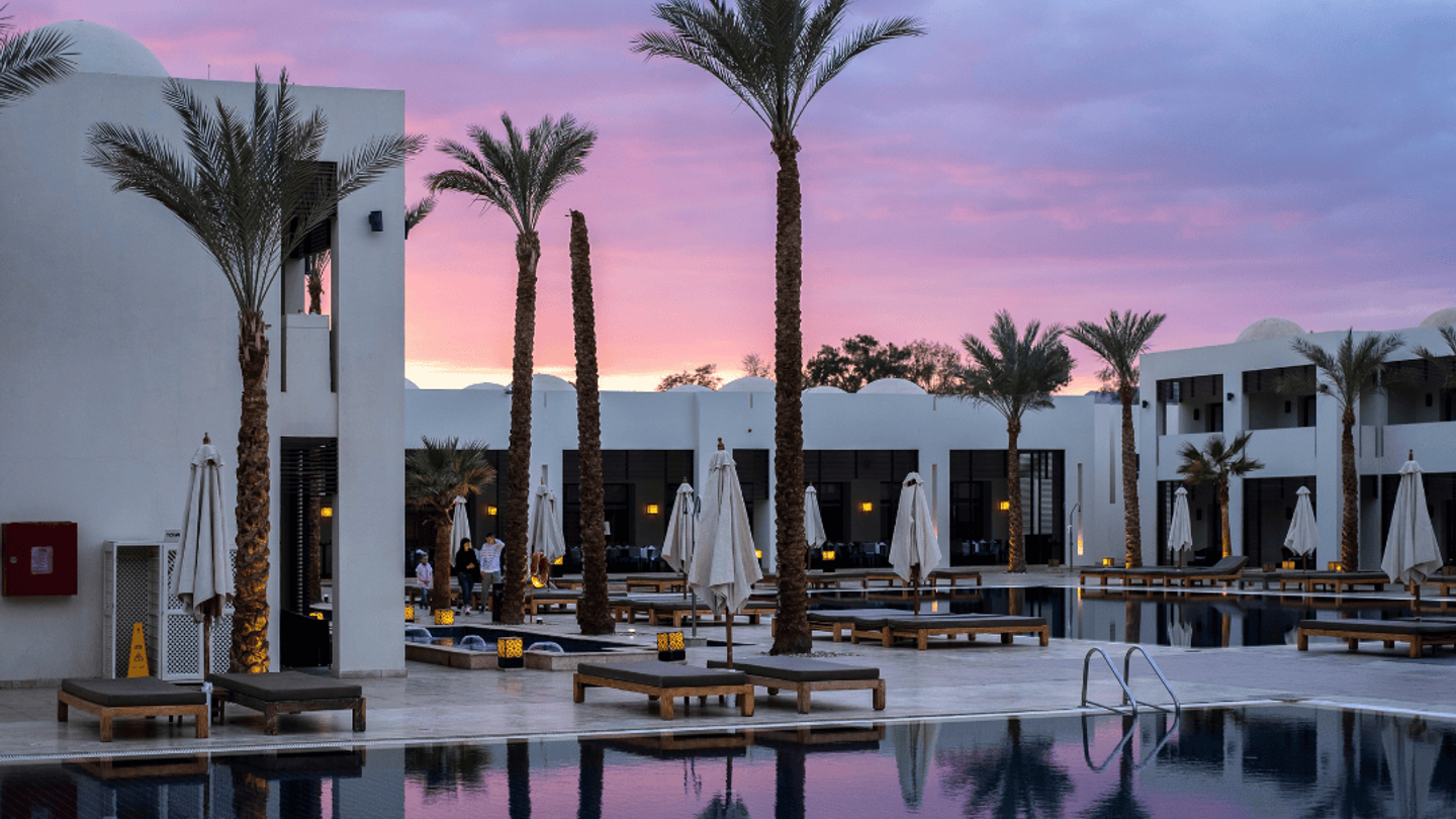 A pink sunset behind a boutique eco hotel.