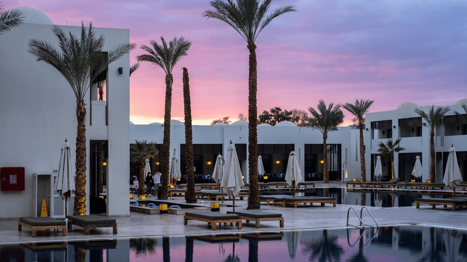A pink sunset behind a boutique eco hotel.