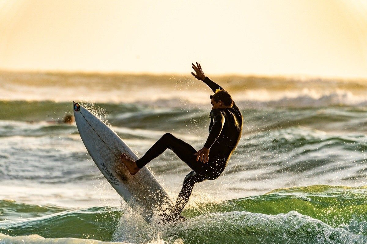 A man surfing in a wetsuit.