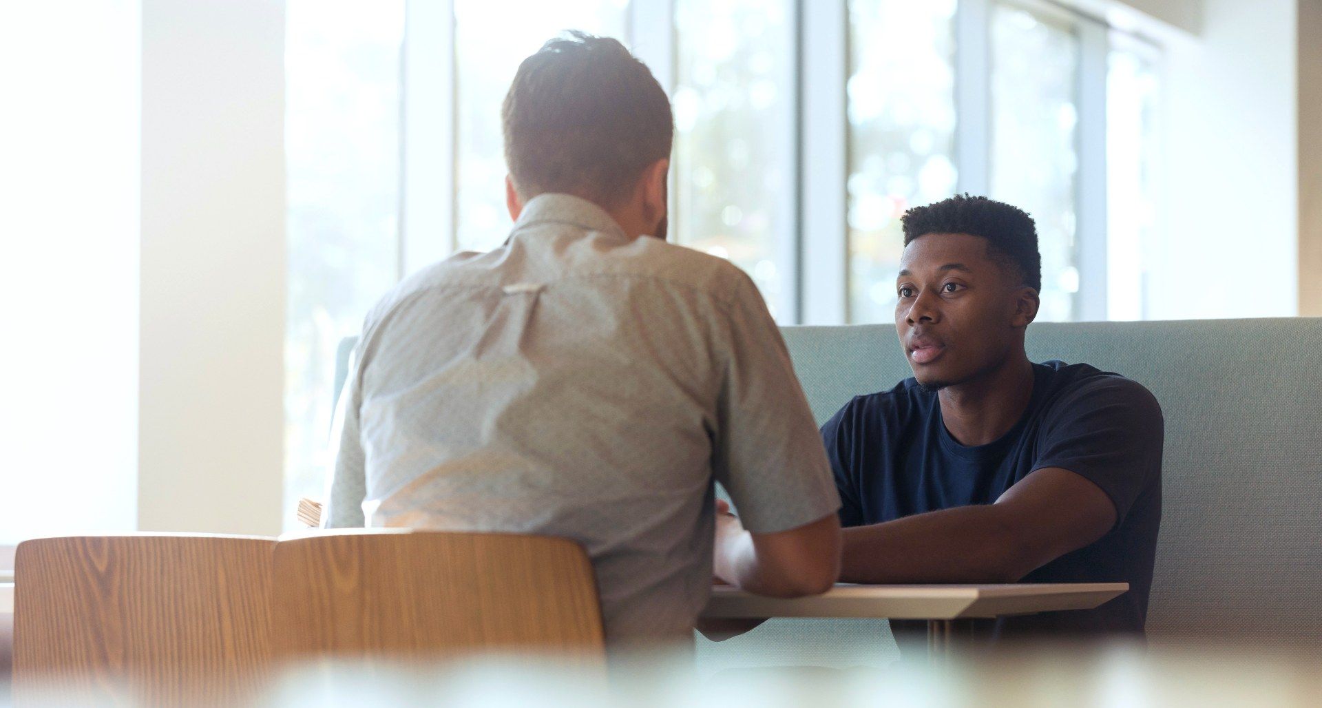 Two men talking across a desk