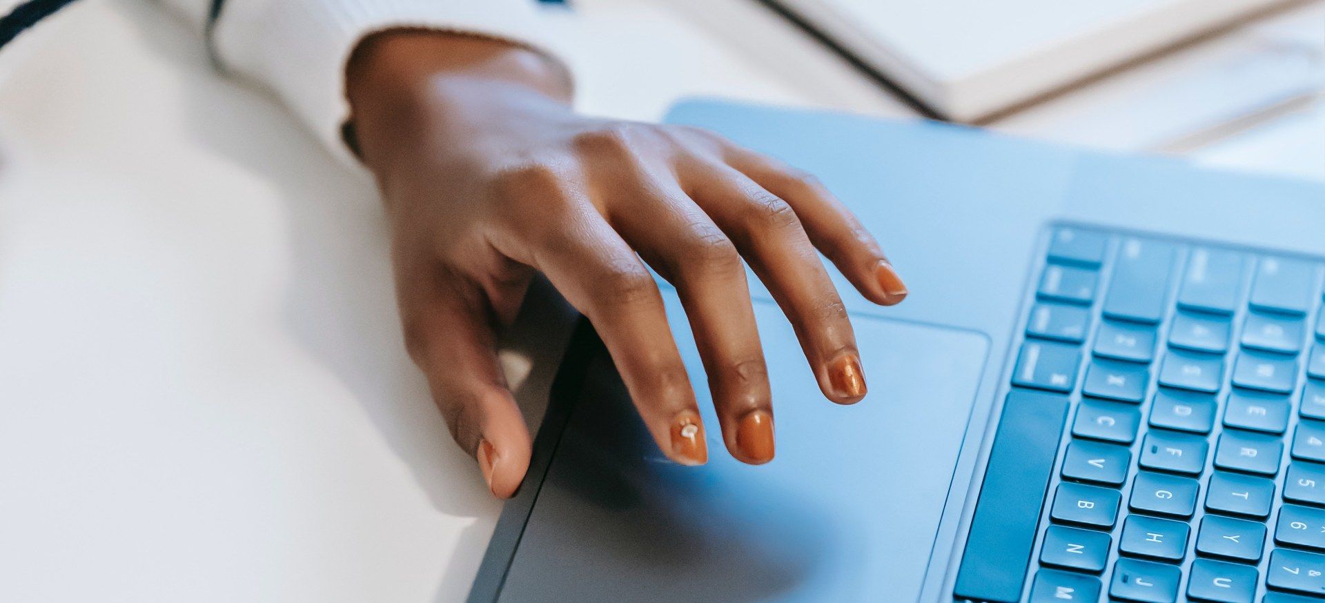 Hand hovering over laptop touchpad