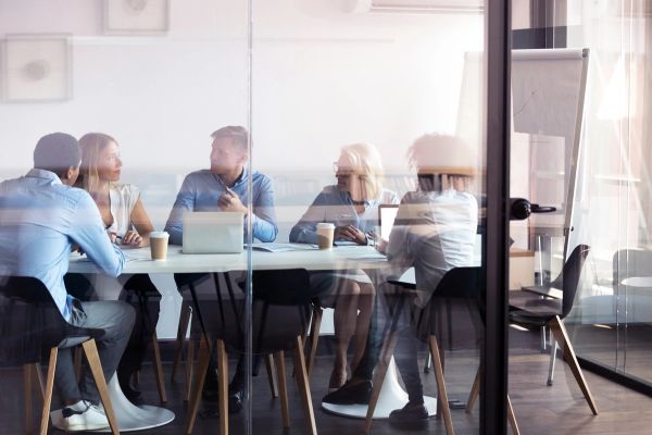 Glass office with a meeting happening inside 