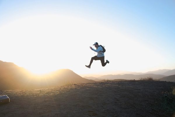 Man jumping high while walking on mountain