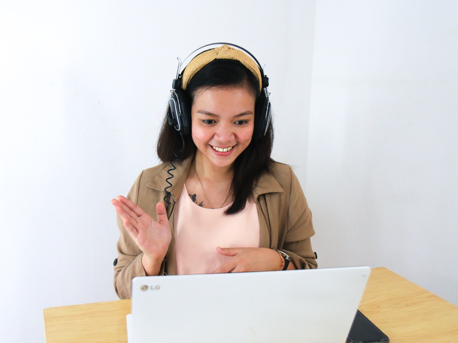 Young girl wearing headband and headphones on a video call on an LG laptop