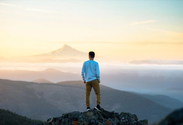 Man on top of mountain looking out into the distance