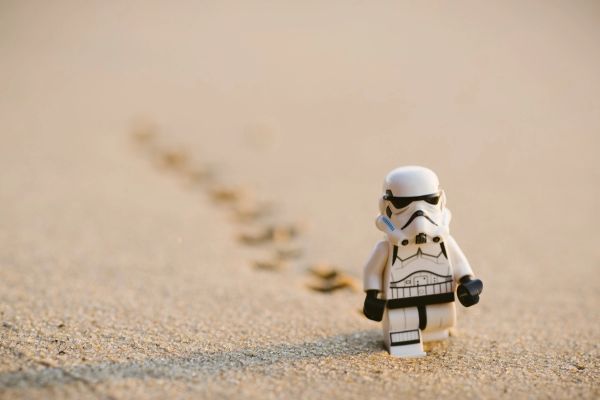 Miniature storm trooper lego figure walking on sand