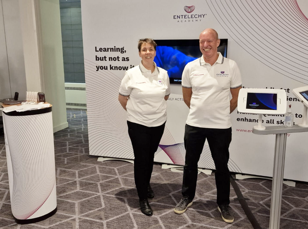 Entelechy employees standing at their exhibition stand