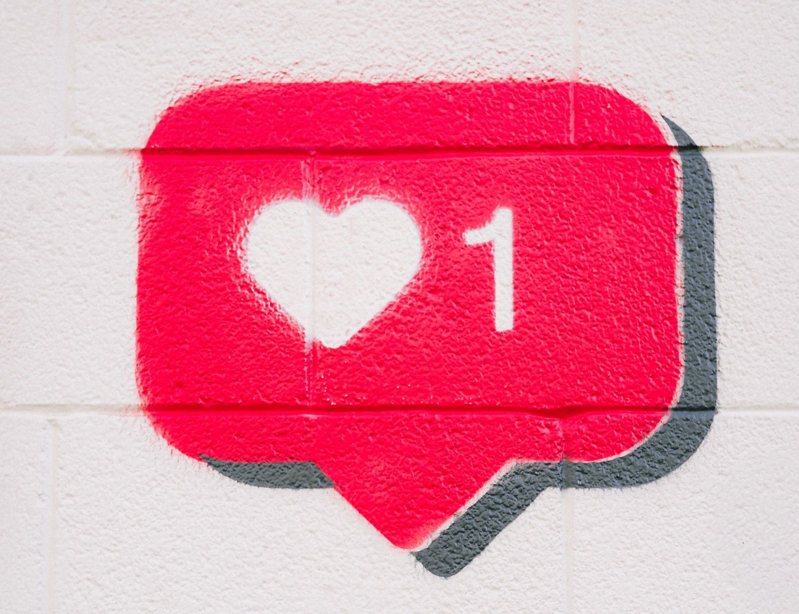 Emoji of red speech bubble with a white heart and the number one
