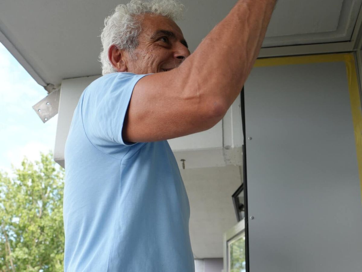 Schilder van Koestr schildert een kozijn