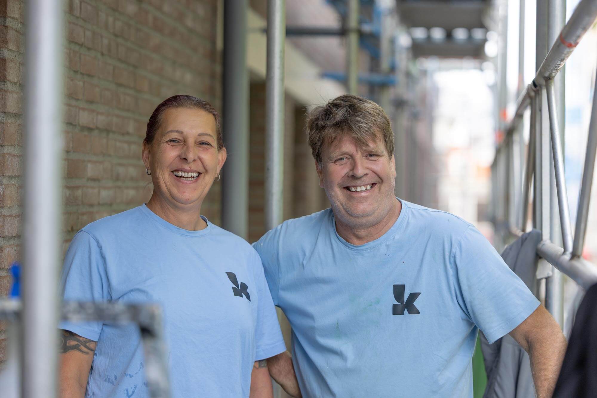 Twee lachende vakmensen van Koestr bij een steiger