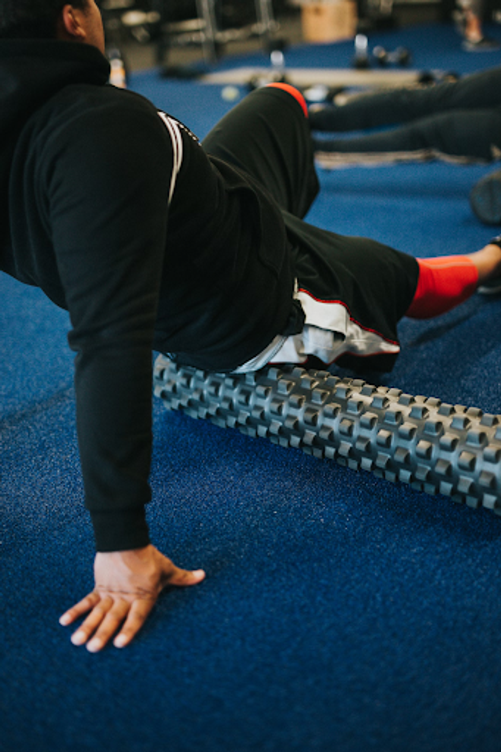 A man at the gym foam rolling his glutes