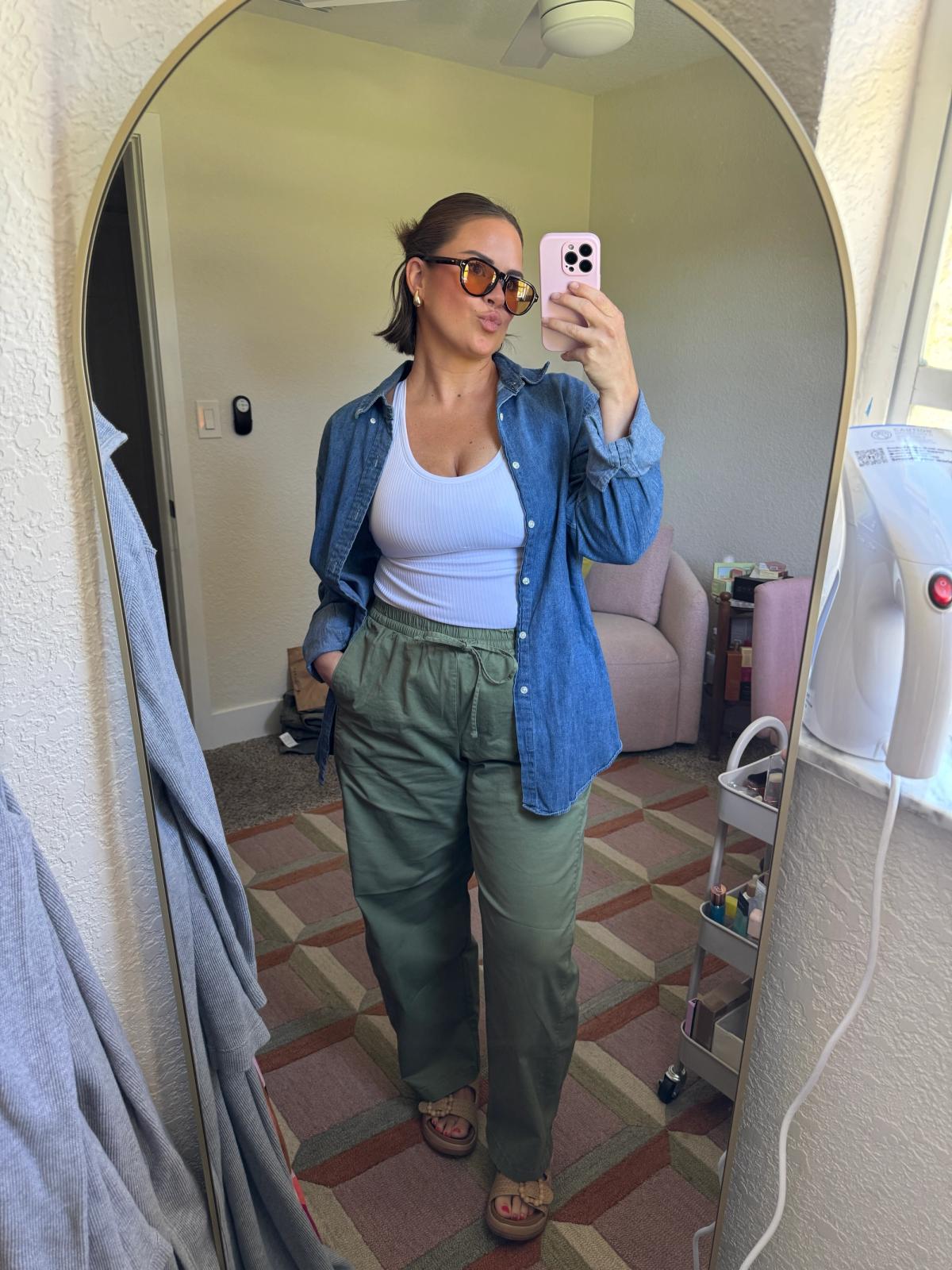 Candace taking a photo of her in an outfit in front of a mirror
