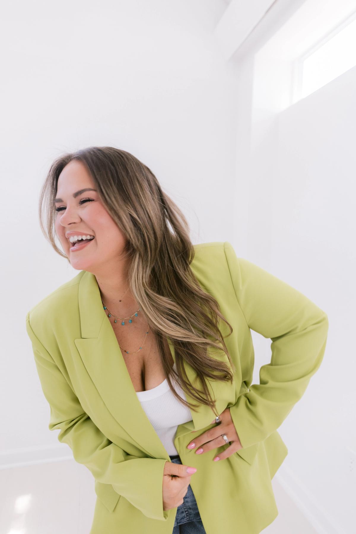 Candace Donnelly laughing, hands on her hips, in a lime green blazer