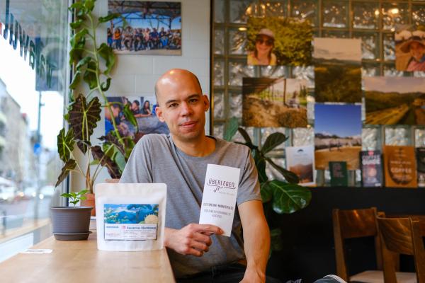 Chris, co-founder of Warawul, sits at the Warawul café with a bag of Cascaritas Chardonnay
