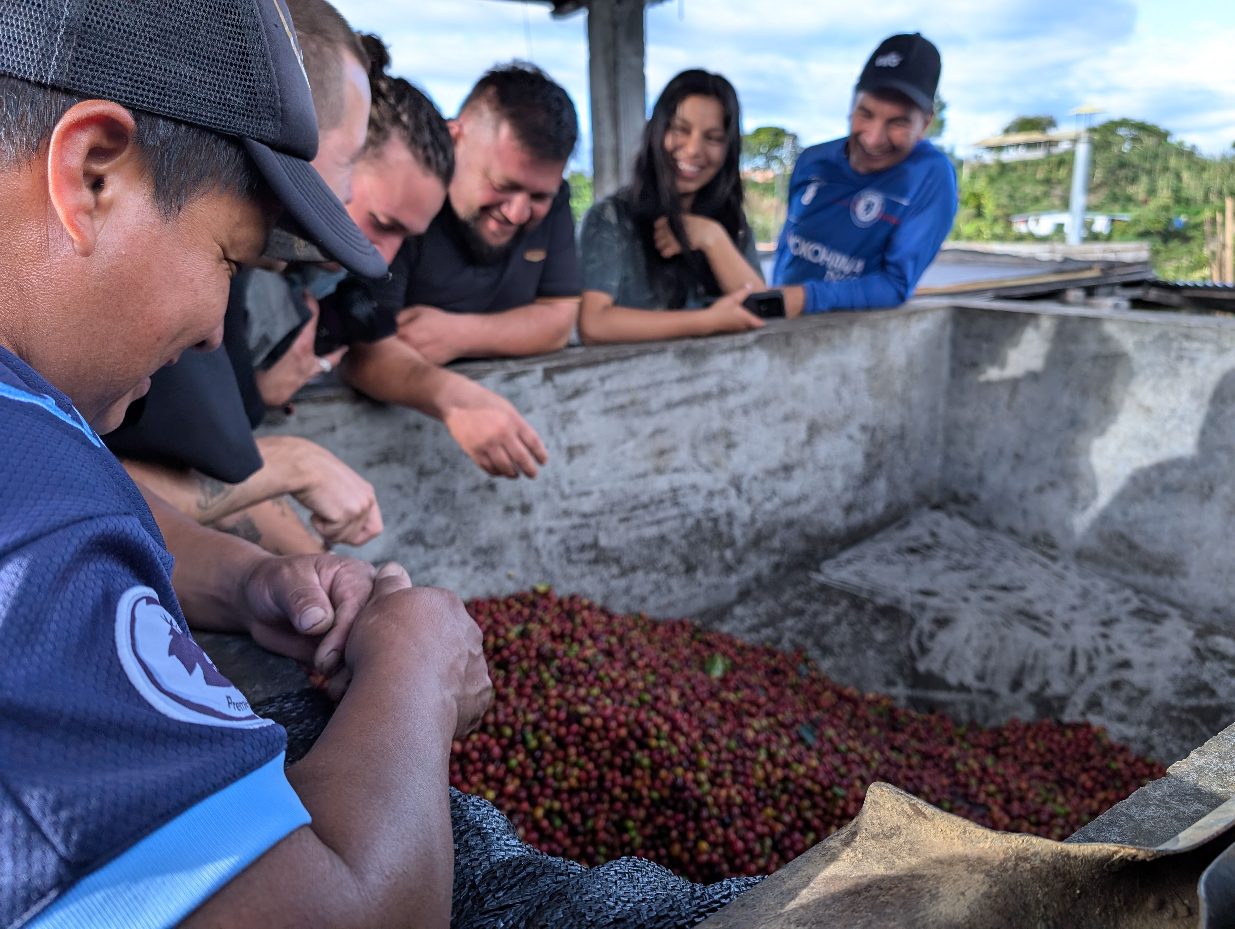 Mitglieder der monKaaba-Gruppe unterhalten sich über einem Fermentationstank.