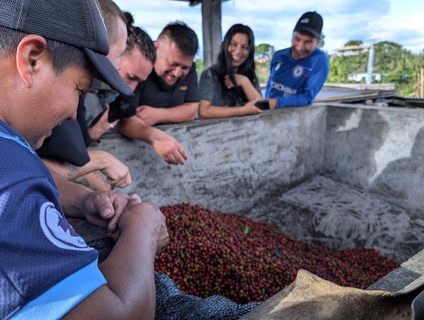 Mitglieder der monKaaba-Gruppe unterhalten sich über einem Fermentationstank.