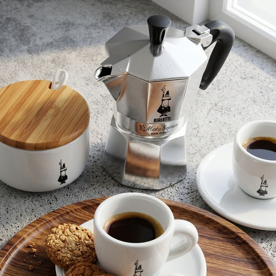 Bialetti neben einem Zuckergefäß und mit Espressotassen 