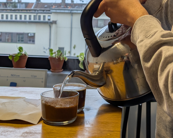 pouring water into a cup of ground coffee beans for quality control