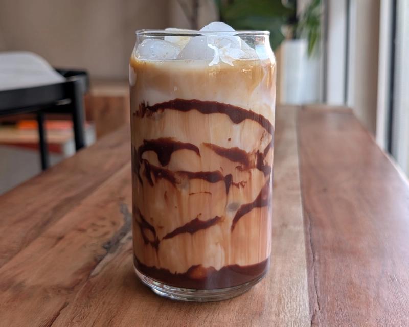 Iced Chocolate Latte in a clear glass with streaks of chocolate syrup