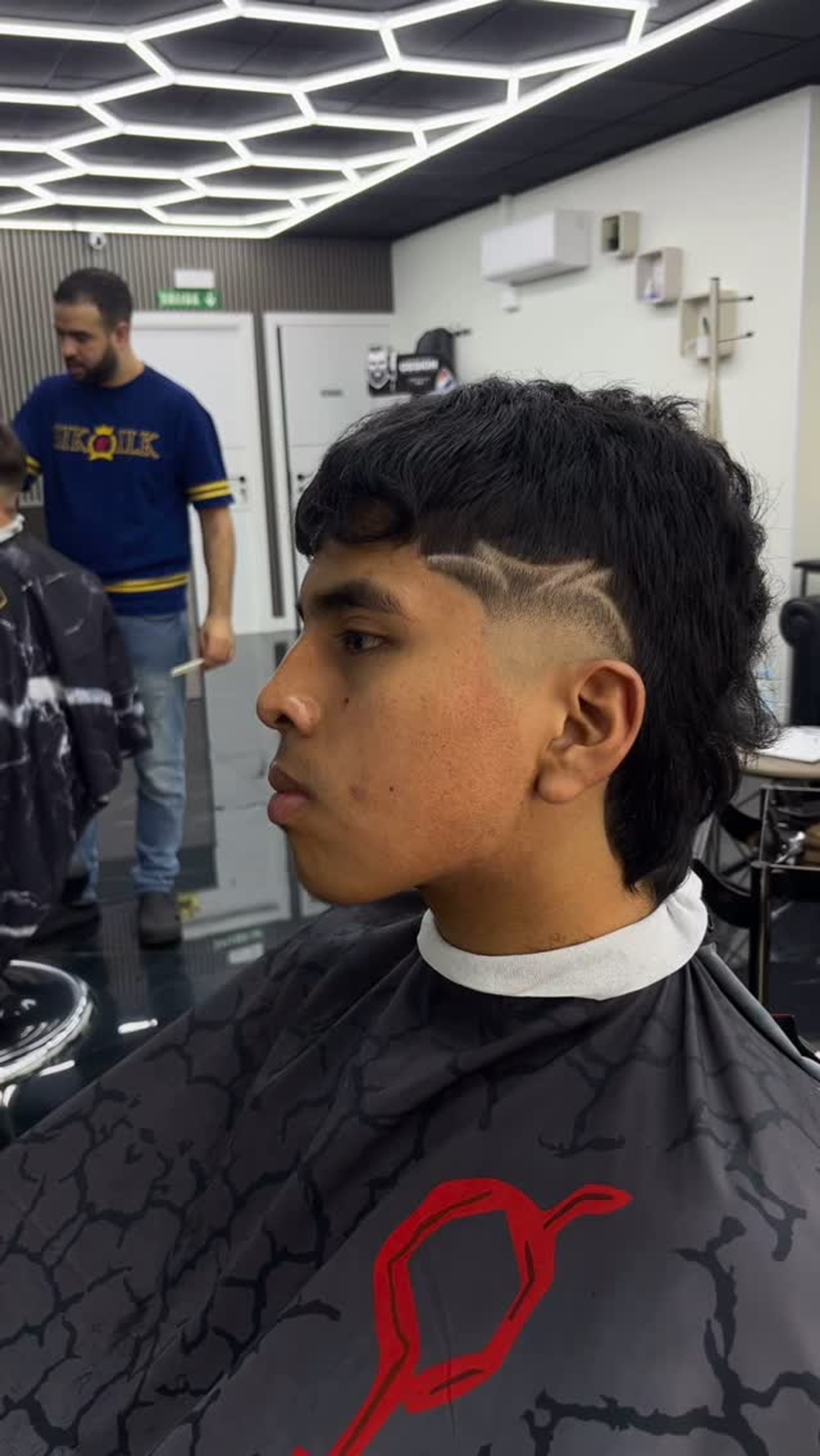 Mullet con una línea rasurada marcada sobre la sien