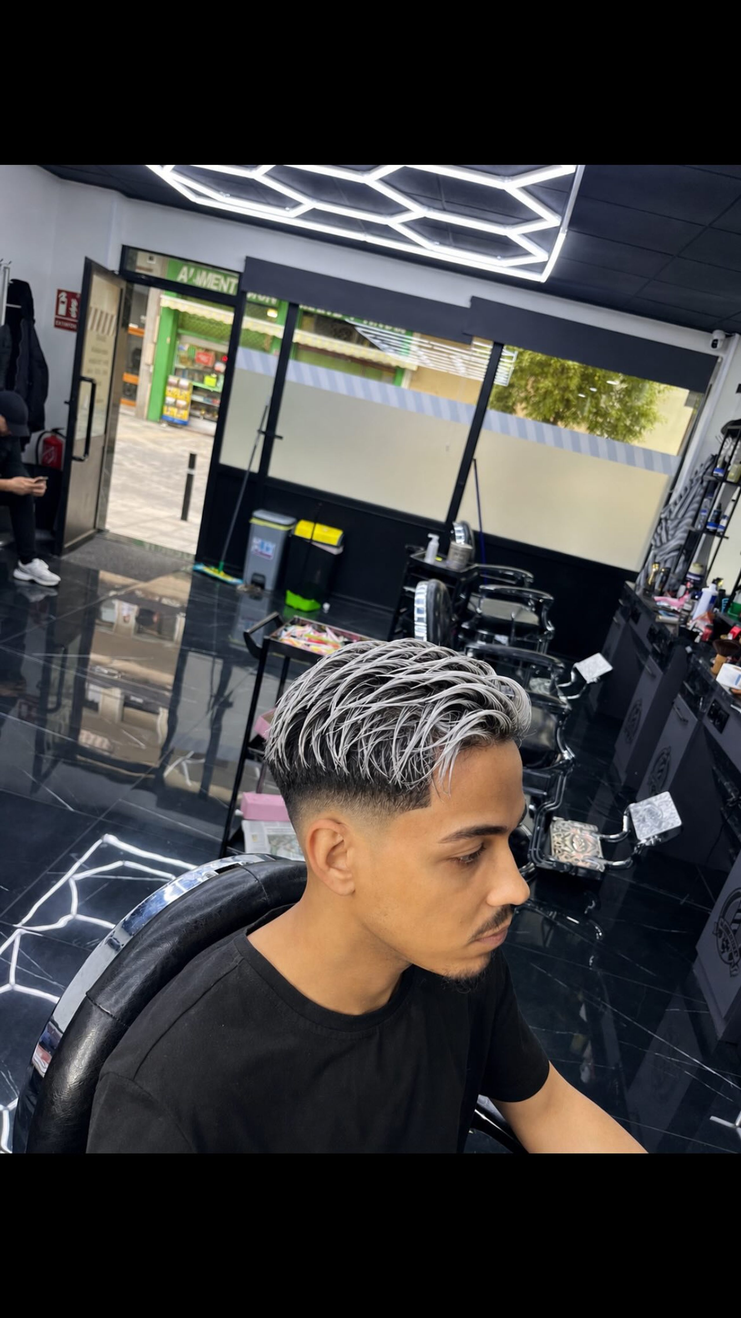 Mechas platinas peinadas hacia arriba con desvanecido en la sien