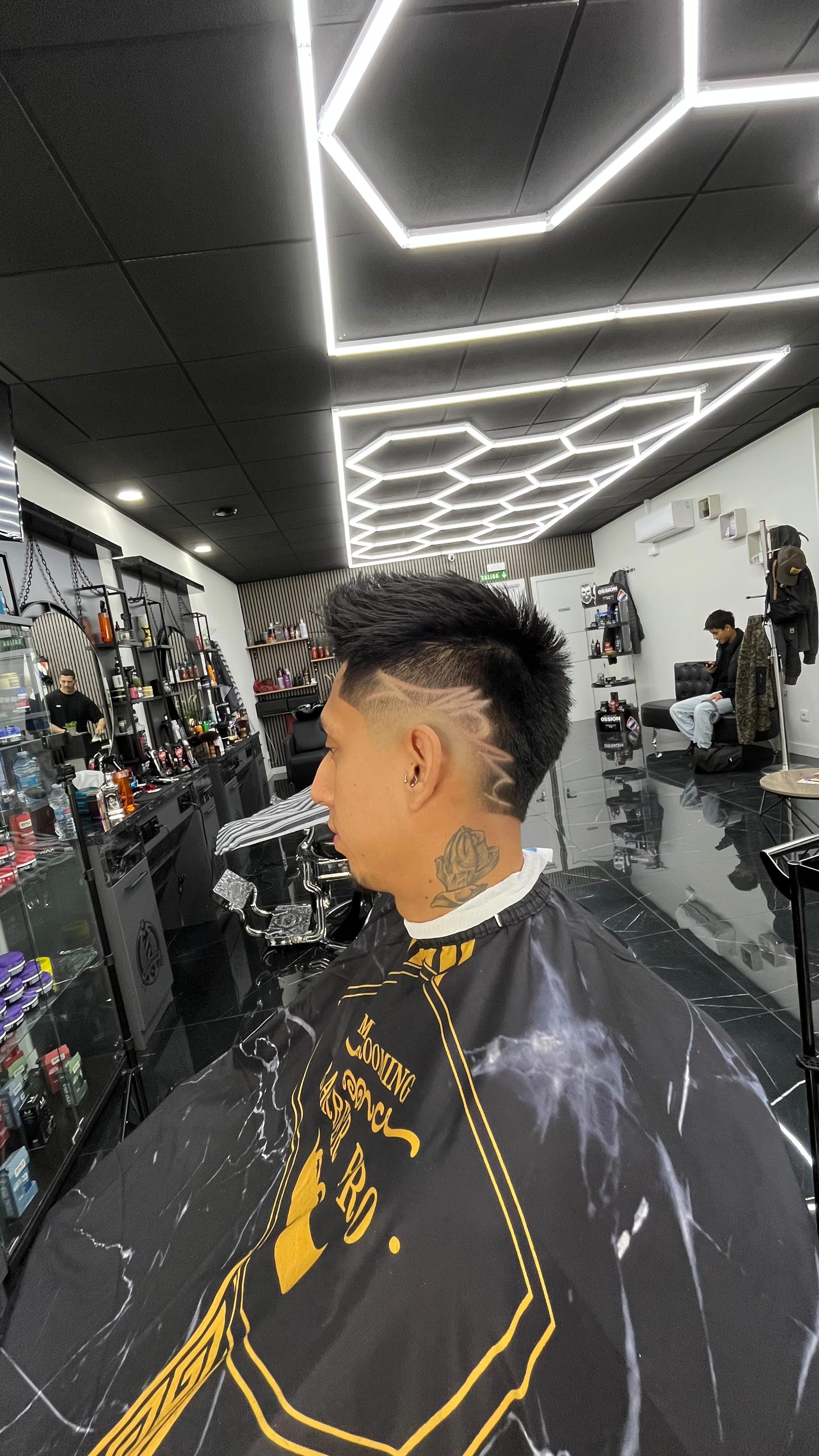 Pelo rubio por arriba con desvanecido, bajo los neones de la barbería