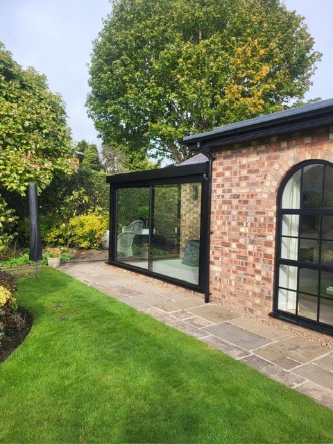 Glass box and arched steel-look window on a red-brick house, Bowdon