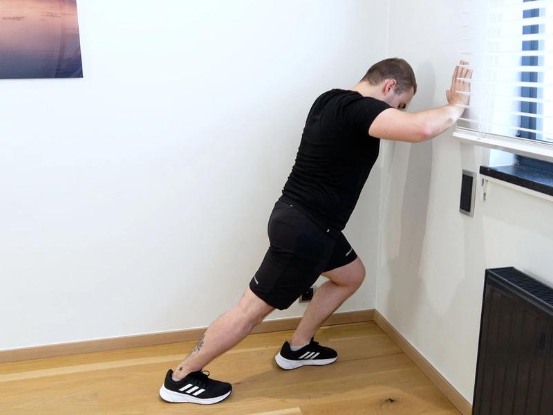 Étirement du triceps sural en fente contre le mur, vue 2