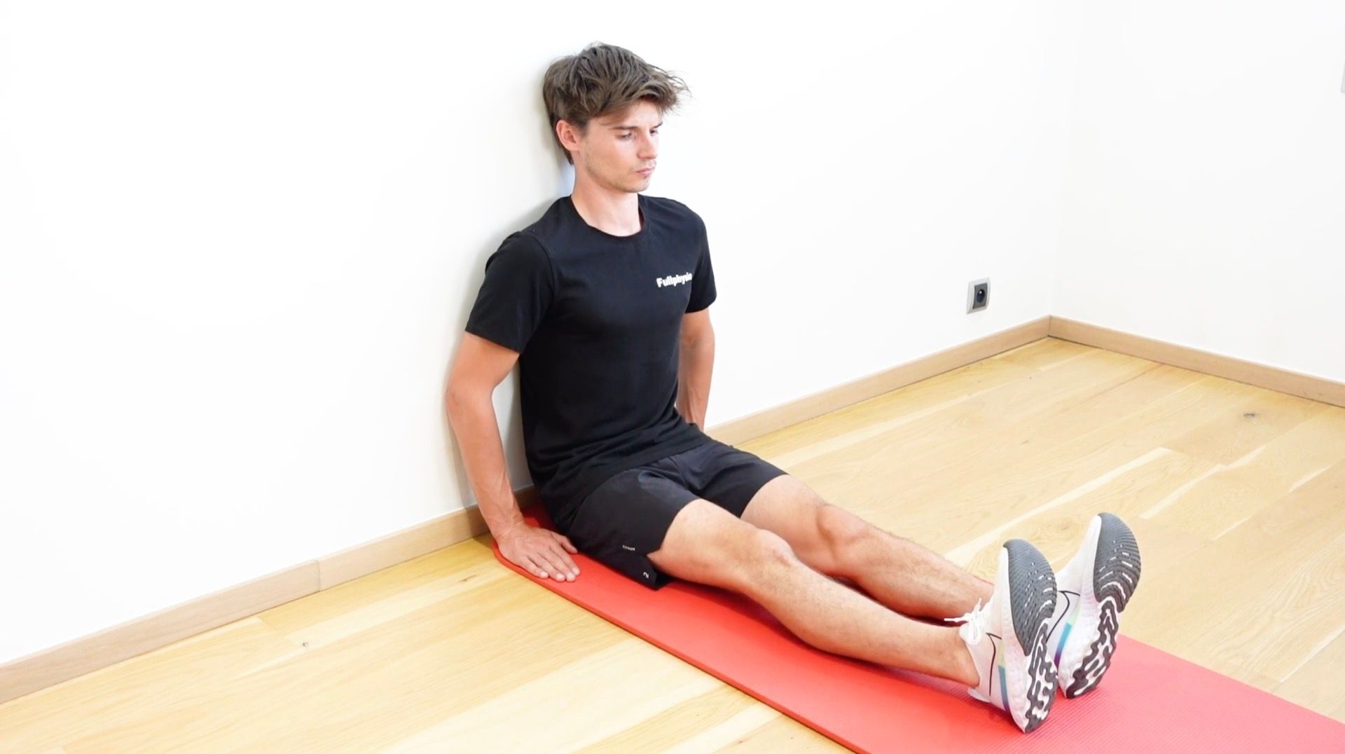 Hip Flexor Strengthening Seated Against a Wall, view 1