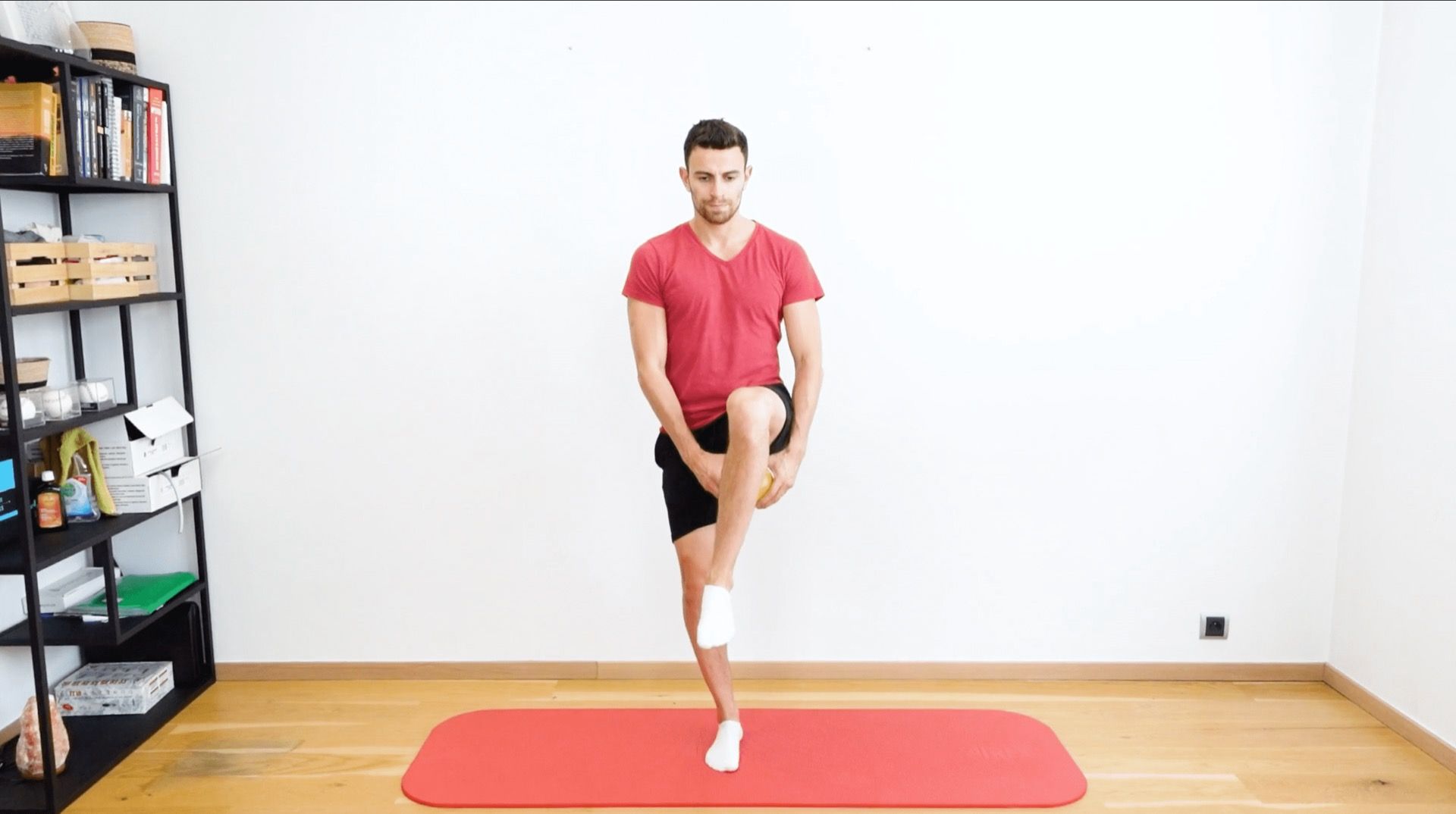Équilibre unipodale avec balle sous la jambe, vue 1