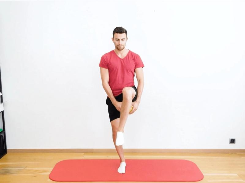 Équilibre unipodale avec balle sous la jambe, vue 1