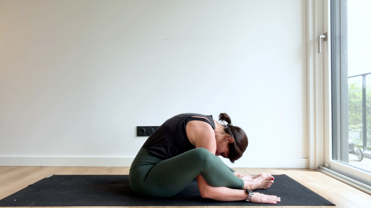 Posture du papillon bras sous les jambes