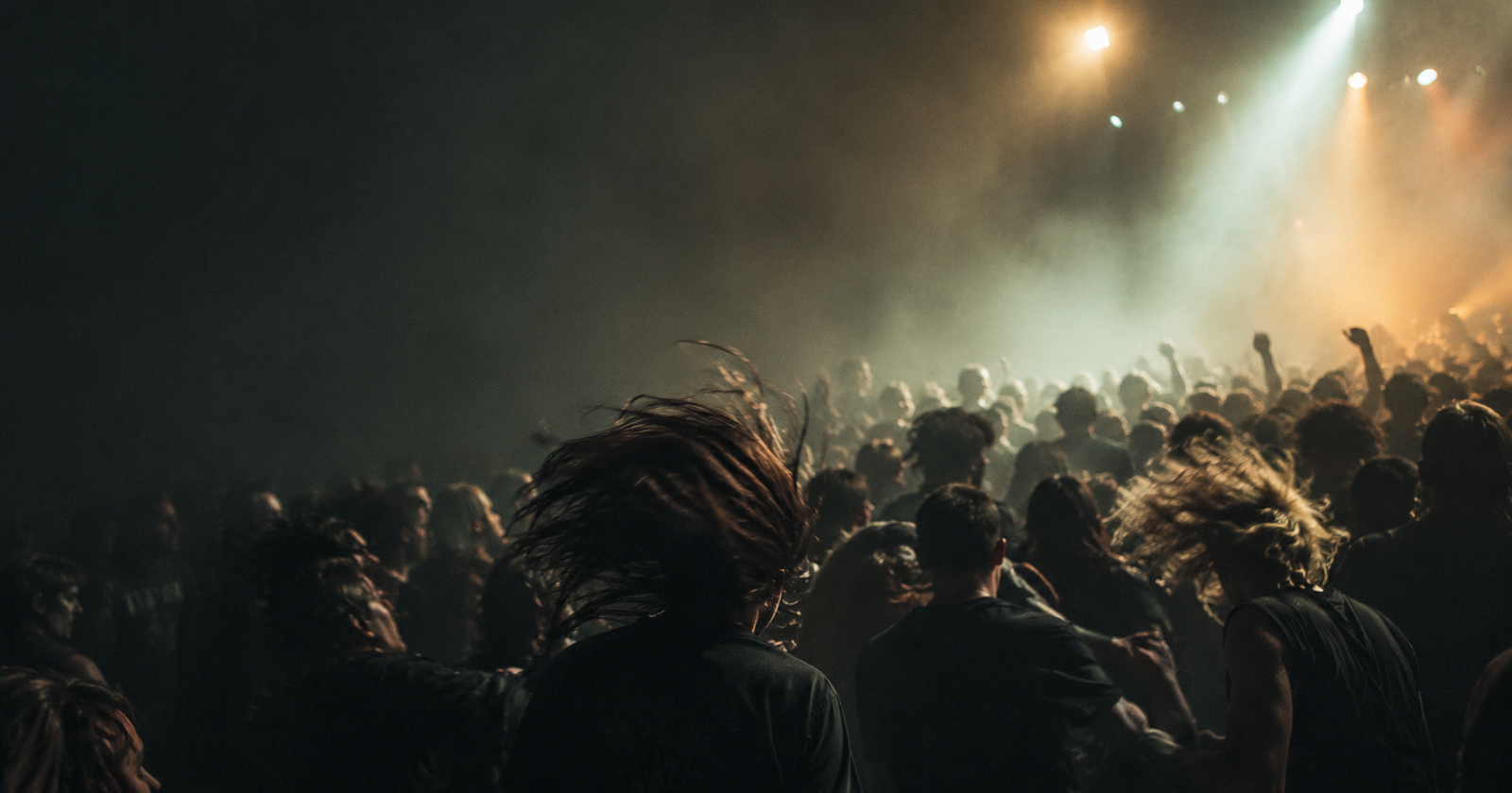 A blurred pit of moving bodies on a packed club floor