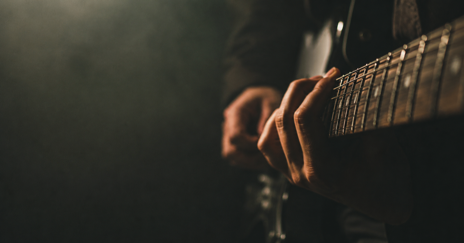 A hand frozen mid-riff on an electric guitar neck