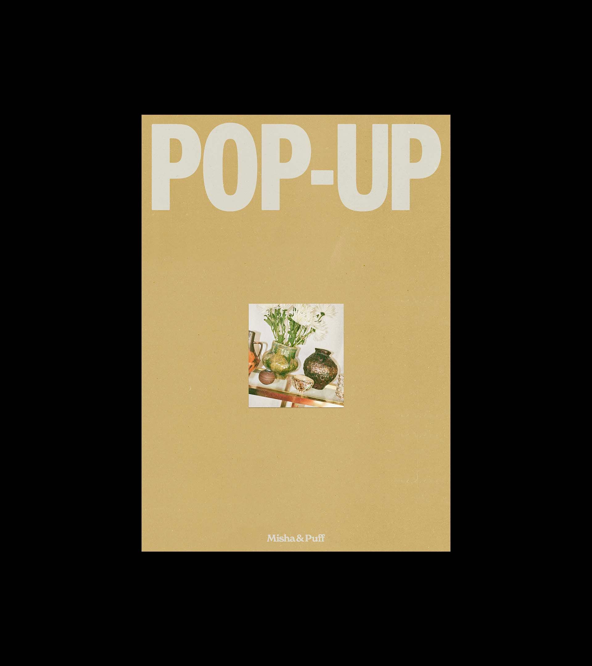 Misha & Puff "POP-UP" poster, tan with oversized bold headline and a small still-life photograph of glass vases.