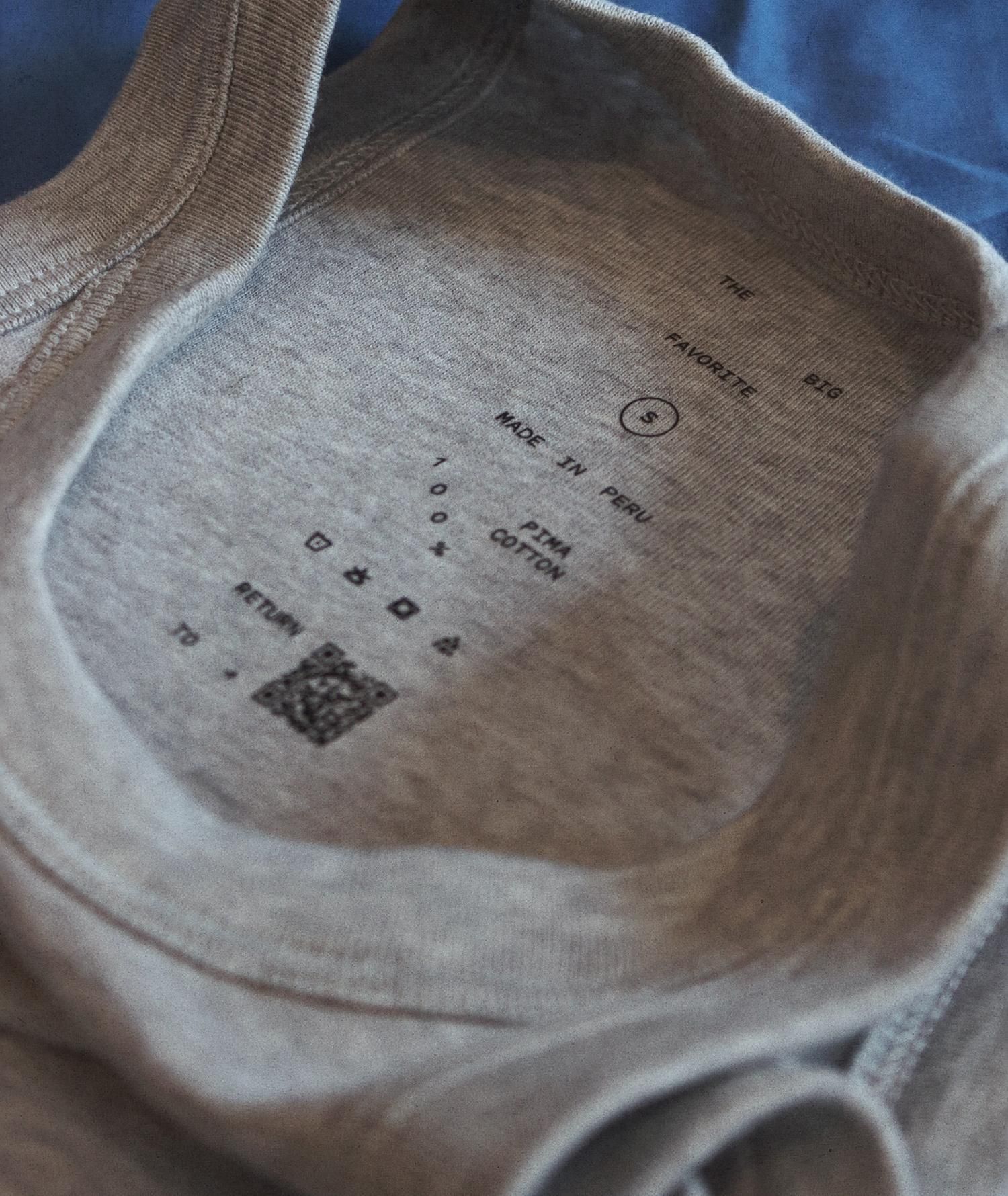 Inside neck label: 'THE BIG FAVORITE / S / MADE IN PERU / 100% PIMA COTTON' with care icons and QR code